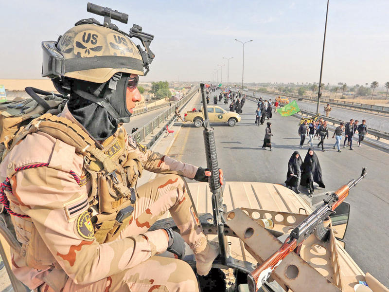  جندي عراقي يجلس على دبابته في إحدى نقاط التفتيش عند مدخل مدينة كربلاء أمس (إي بي أيه)