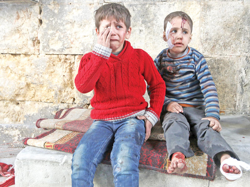 أخوان أحدهما يبكي والآخر مذهول من كثافة القصف خارج مستشفى ميداني بحلب الشرقية أمس (رويترز)