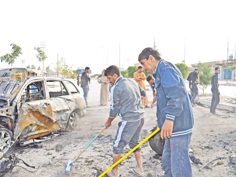 عراقيون ينظفون مكان التفجير الذي استهدف حفل زفاف في الفلوجة أمس  (رويترز)