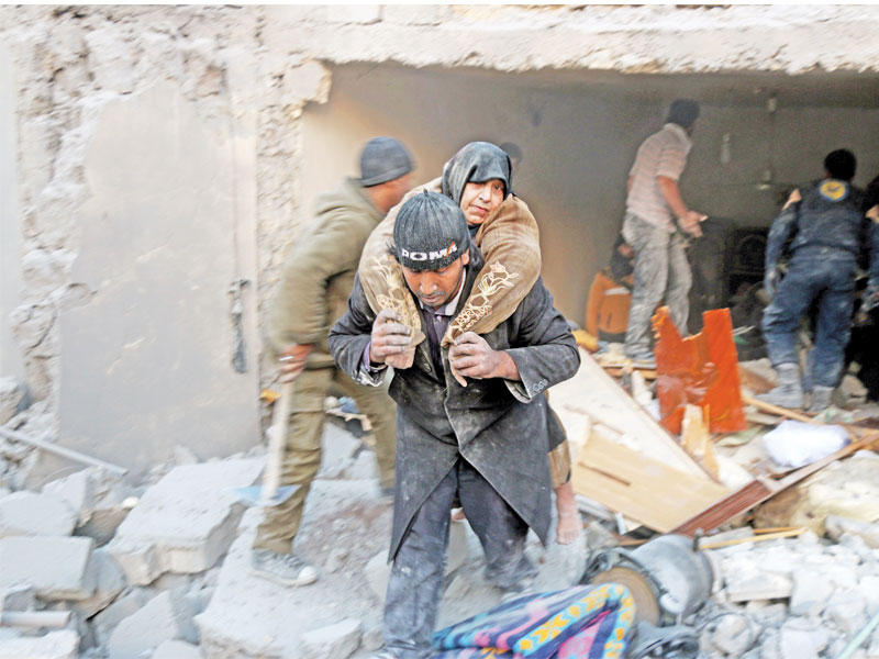 سوري يجلي مسنة من تحت أنقاض منزلها المدمر في غارة نظامية على حلب الشرقية أمس الأولt(أ ف ب)