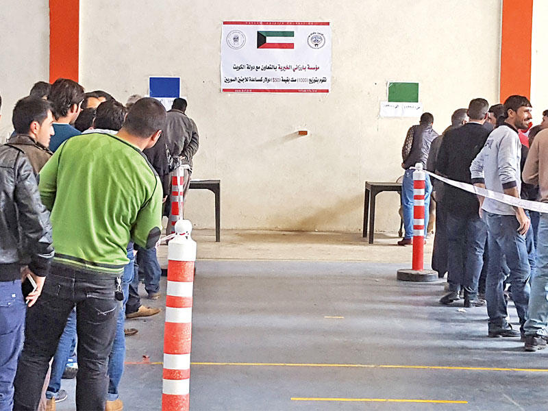 جانب من توزيع القسائم الشرائية على النازحين السوريين