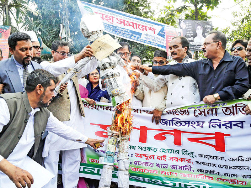 أنصار حزب عوامي يحرقون دمية الزعيمة البورمية أون سان سو تشي في دكا أمس (اي بي ايه)