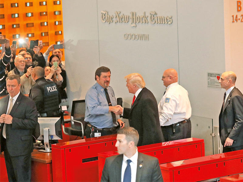 ترامب يحيي موظف الأمن على مدخل صحيفة «نيويورك تايمز» التي زارها مساء أمس الأولt(أ ف ب)