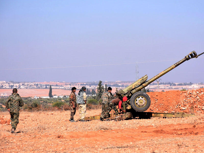 مقاتلون موالون للنظام يوجهون مدفعاً روسياً نحو منطقة الباب في محافظة حلب أمس (أ ف ب)n