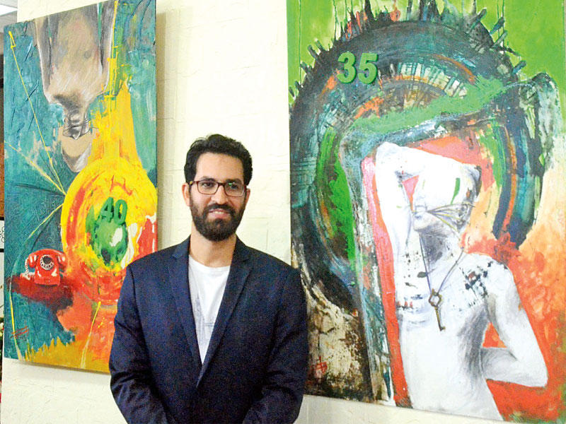 الفنان سيف الدين أمام أحد أعماله الفنيةn