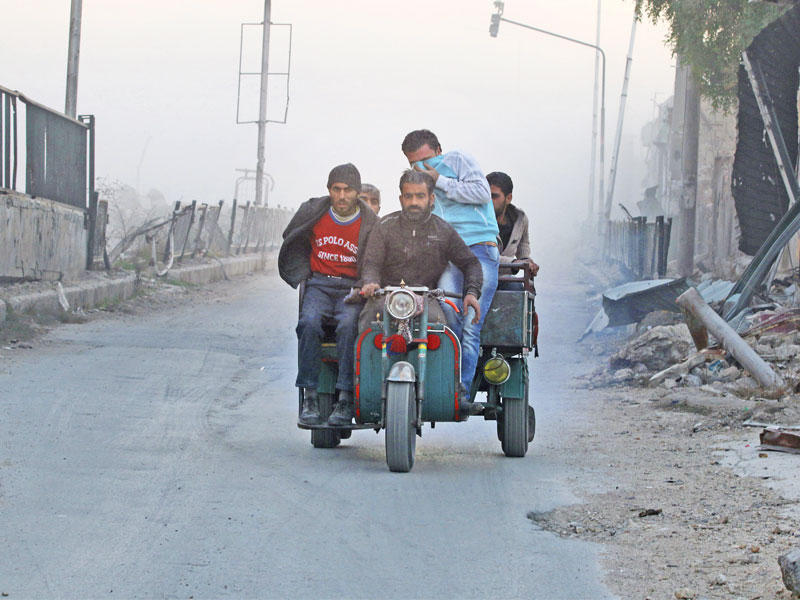 سوريون يفرون من حي الصاخور بحلب الشرقية أمس (رويترز)