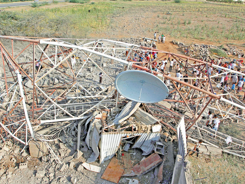 يمنيون متجمعون حول برج اتصالات بعد غارة جوية أمس  (رويترز)