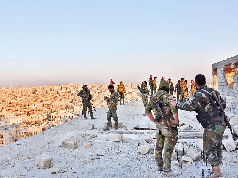 جنود موالون للنظام فوق مبنى يشرف على حي البستان في حلب الشرقية أمس (أ ف ب)