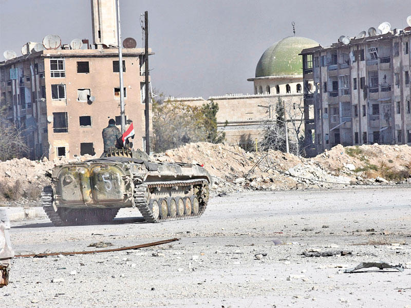 مدرعة نظامية في حي الحيدرية بحلب الشرقية أمس الأول  (رويترز)