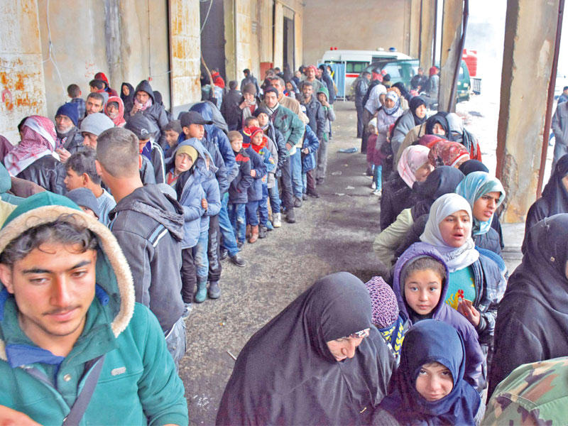 حشود من النازحين تصطف للحصول على الغذاء بقرية صغيرة بضواحي حلب الشرقية أمس n (أ ف ب)