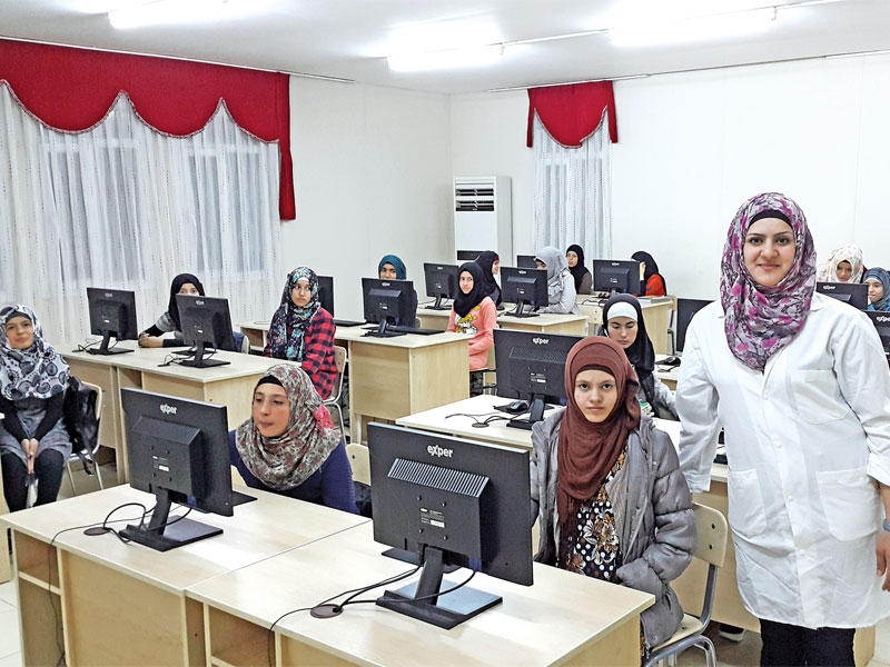 المعلمة خنساء السعيد مع مجموعة من طالبات قرية «صباح الأحمد»