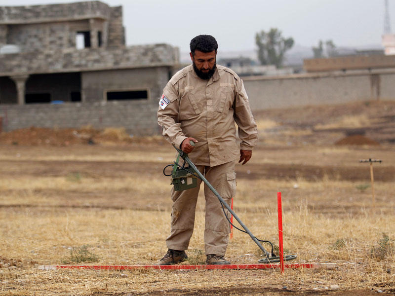 عسكري عراقي يبحث عن الألغام في منطقة كريزز قرب الموصل مساء أمس الأول (رويترز)