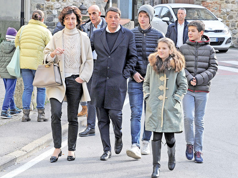 رينزي وعائلته يتوجهون الى مركز لللاقتراع في فلورنسا شمال ايطاليا امس (رويترز)