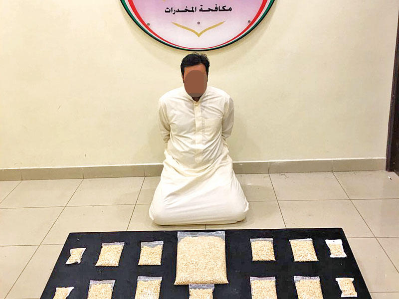 المتهم وأمامه الحبوب المخدرة والأسلحة النارية