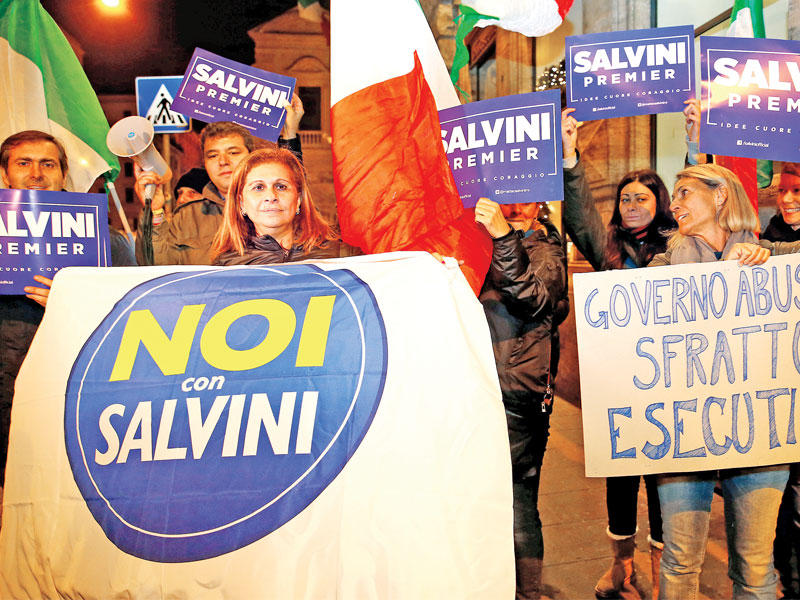 مؤيدون لحزب رابطة الشمال يحتفلون برفض الإصلاحات الدستورية رافعين لافتات كتب عليها «حكومة غير شرعية» أمام قصر شيجي في روما فجر أمس (رويترز)