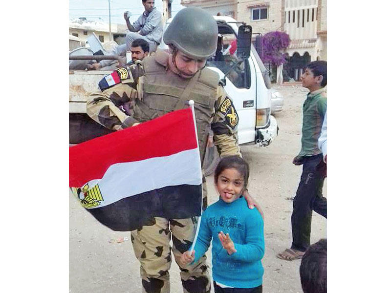 طفلة إلى جانب جندي خلال عودة بعض الأهالي إلى سيناء