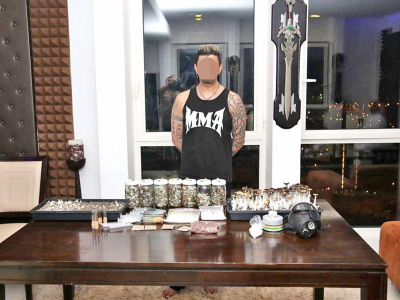 المتهم وأمامه المضبوطات