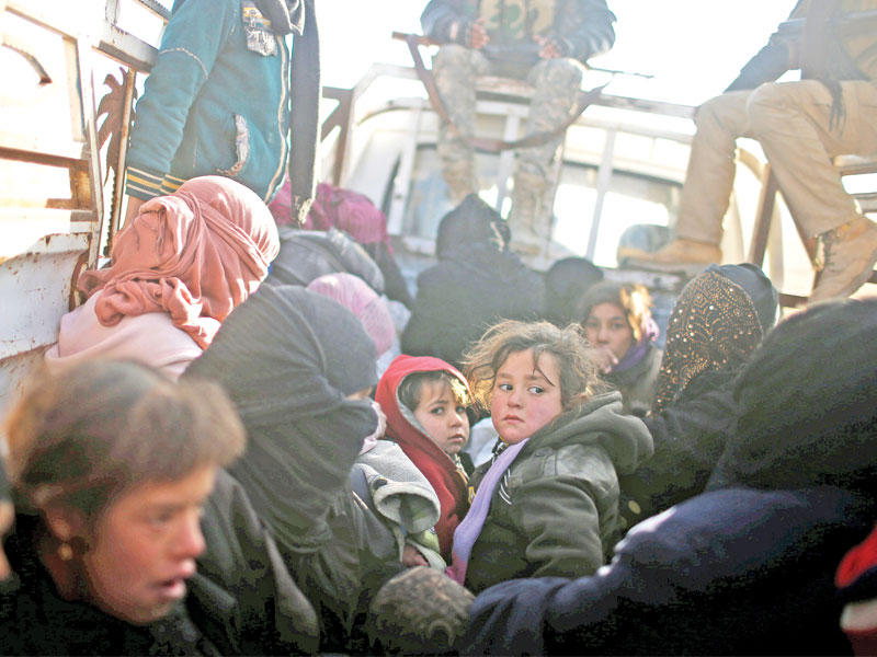 نساء وأطفال عراقيون فارون من الموصل يتكدسون في شاحنة أمس (رويترز)