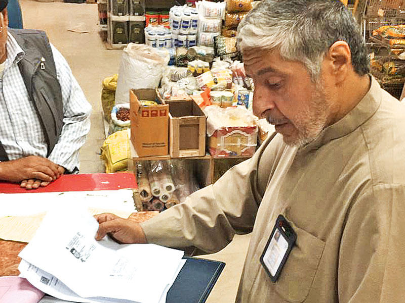 أحد مفتشي البلدية يحرر إحدى المخالفات في الشويخ 