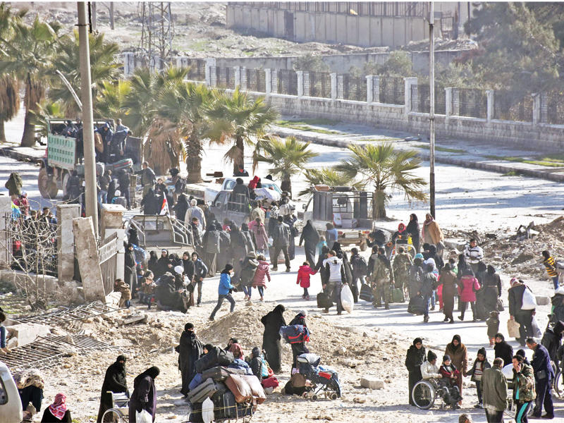 سوريون يغادرون حلب الشرقية عبر نقطة تفتيش تابعة للنظام أمس  (أ ف ب)