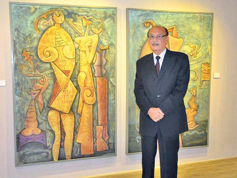 الفنان أحمد شيحا أمام إحدى لوحاته