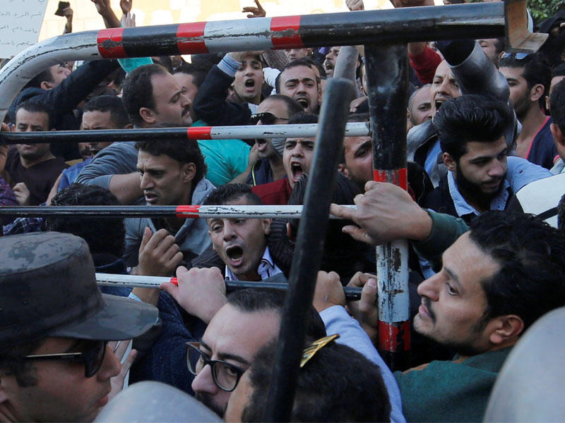 شبان أقباط يحاولون المشاركة في جنازة الضحايا أمس (رويترز)