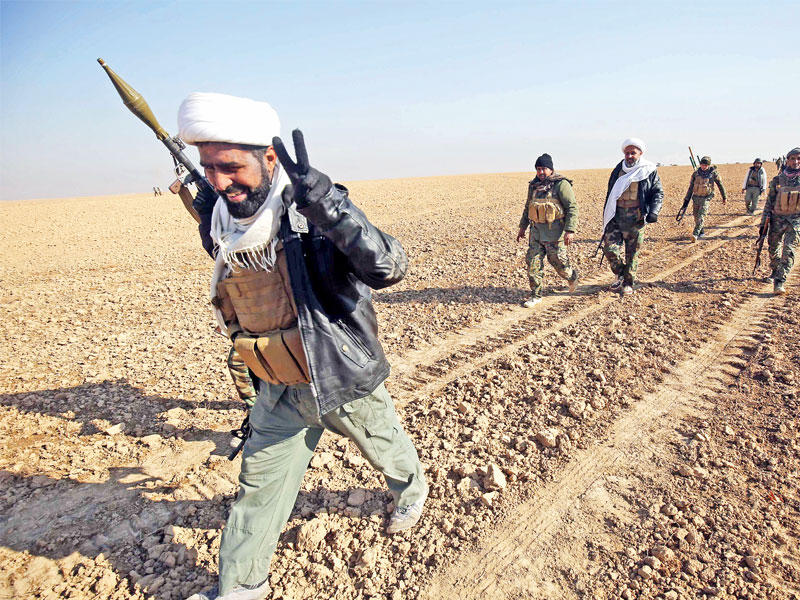 مقاتلون في «الحشد» بينهم «معممون» يتقدمون باتجاه مدينة الشواح غرب الموصل أمس (أ ف ب)