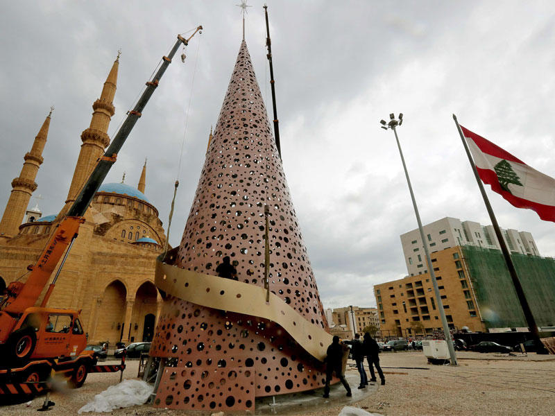شجرة الميلاد وخلفها جامع الأمين في وسط بيروت بساحة الشهداء أمس  ( أ ف ب)