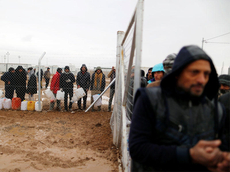 عراقيون بانتظار الحصول على مياه داخل معسكر لإيواء النازحين شمالي الموصل أمس الأول (رويترز)