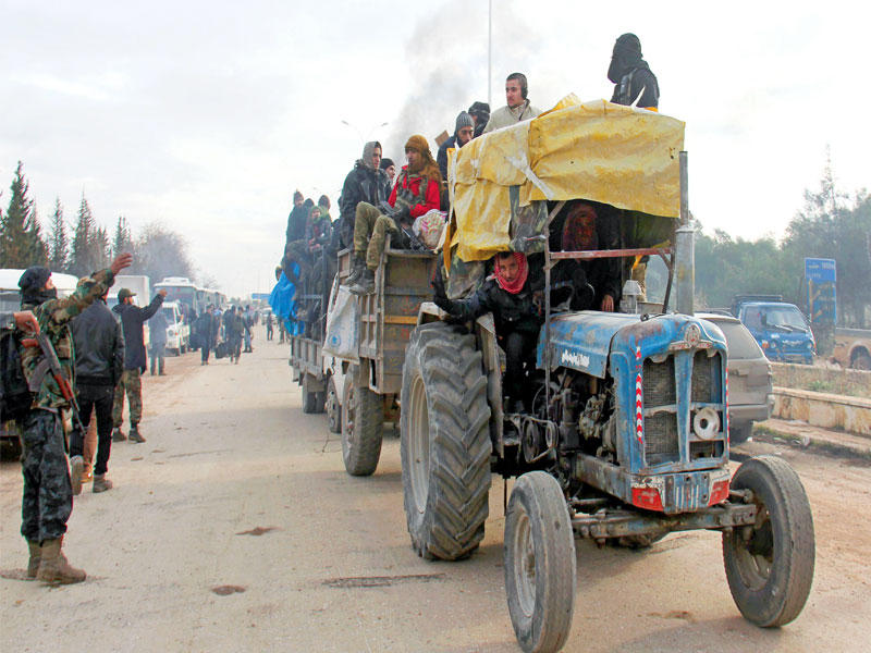 مقاتلون ومدنيون خارجون من حلب الشرقية يصلون إلى حي خان العسل غرب المدينة أمس (أ ف ب)