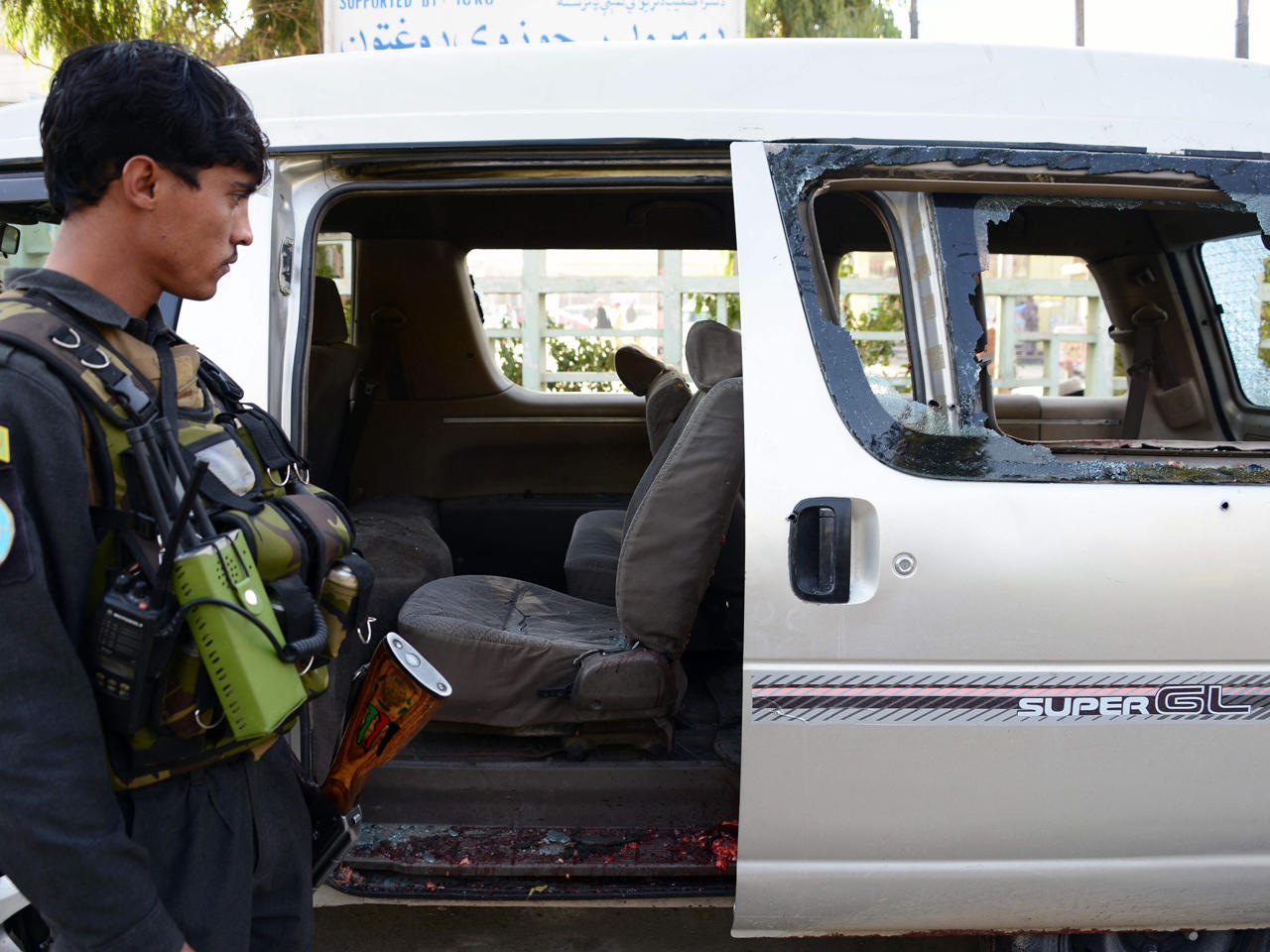 شرطي أفغاني يعاين الحافلة التي كانت تقل الموظفات