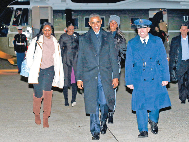 أوباما وعائلته بعد هبوطهما في هاواي لقضاء عطلة عائلية أمس الأول (رويترز)