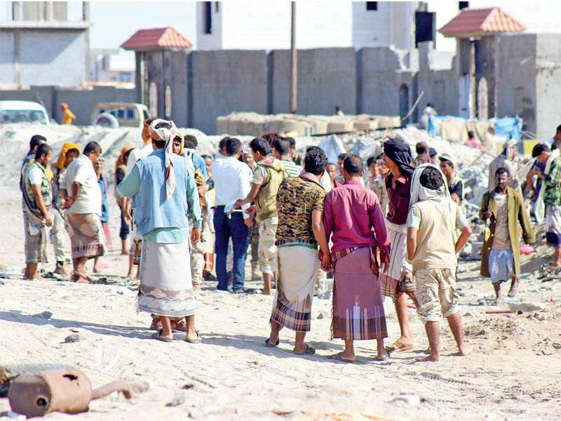 يمنيون في موقع التفجير الانتحاري في عدن أمس (إي بي إيه)