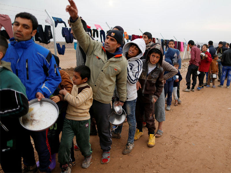 نازحون من الموصل ينتظرون دورهم للحصول على طعام يومي في مخيم قرب الموصل أمسt(رويترز)