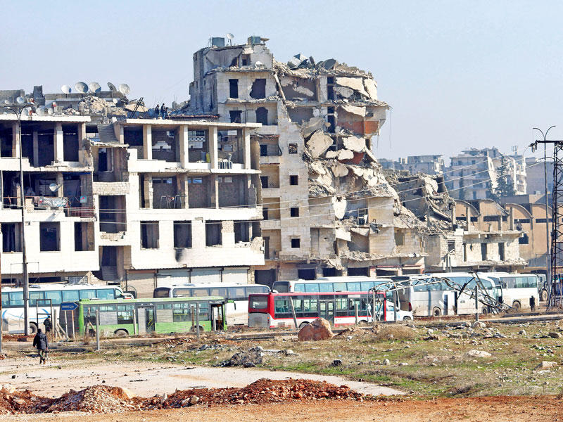 حافلات تنتظر إجلاء المزيد من المدنيين من حلب الشرقية أمس (إي بي إيه)