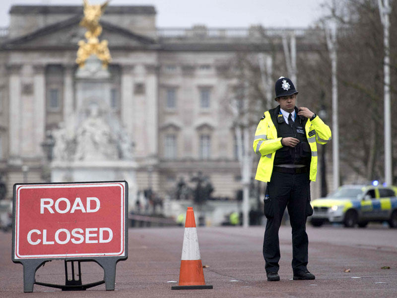 رجل أمن في محيط ساحة قصر باكنغهام التي أُغلقت لمنع التجمهر أثناء مراسم تغيير حراسة القصر وسط لندن أمس (أ ف ب)