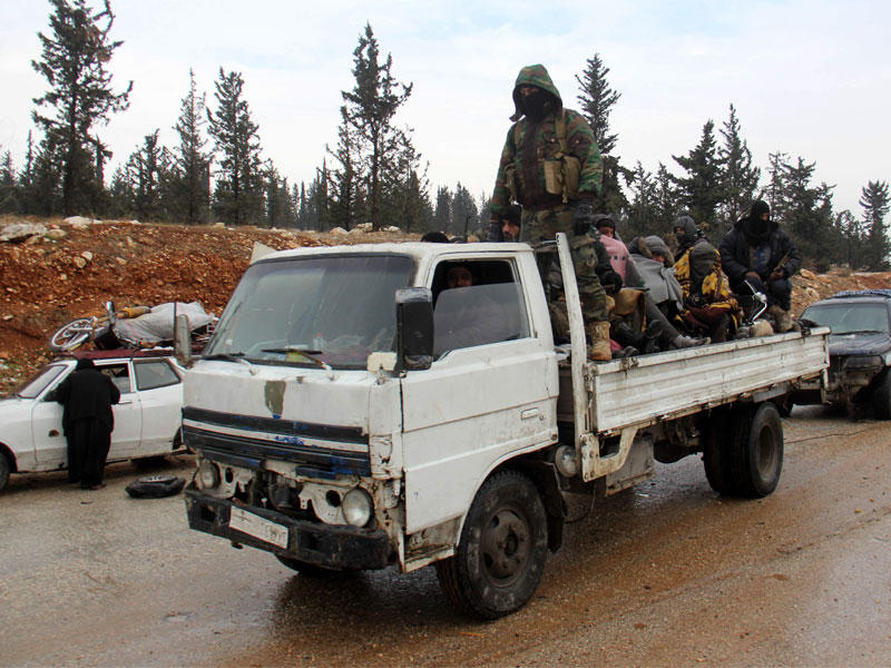 مقاتلون سوريون يغادرون منطقة الراشدين على متن شاحنة أمس (أ ف ب)