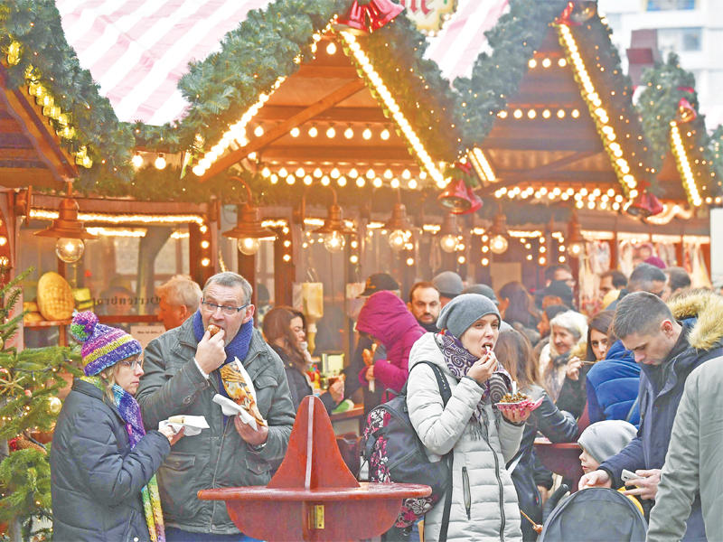 ألمان يتناولون وجبات سريعة في سوق عيد الميلاد ببرلين أمس (أ ف ب)