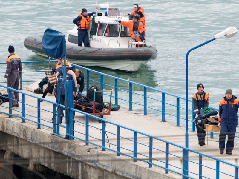 رجال إنقاذ روس ينقلون أمتعة للركاب على رصيف البحر الأسود خارج سوتشي أمس (أ ف ب)n