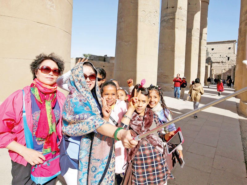 سائحات يلتقطن صورة سيلفي بمدينة الأقصر في 14 ديسمبر (رويترز)