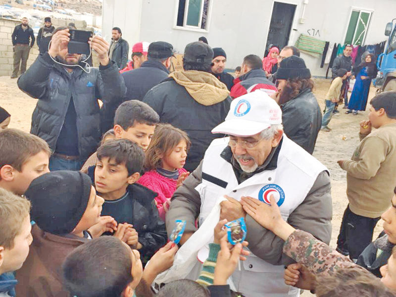 الساير موزعاً المساعدات على النازحين السوريين 