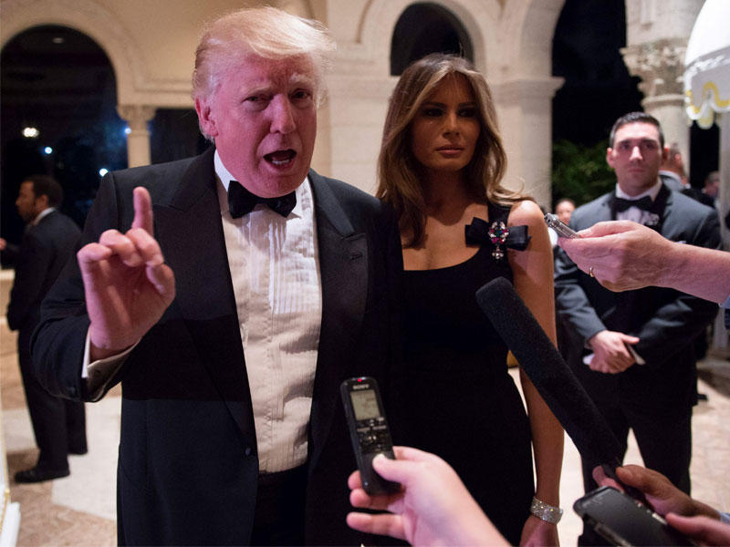  ترامب متحدثاً إلى الصحافيين برفقة زوجته ميلانيا في ليلة رأس السنة في بالم بيتش بولاية فلوريدا (أ ف ب)