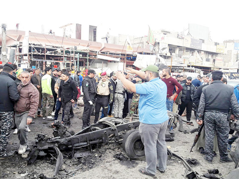 عراقيون يتفقدون مكان الانفجار في مدينة الصدر أمس (إي بي أيه)