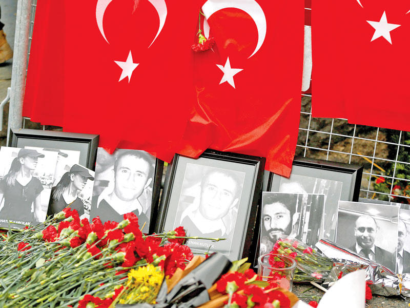 زهور وأعلام تركية أمام مدخل مطعم ومقهى رينا في إسطنبول تكريماً لضحايا الهجوم الإرهابي (رويترز)