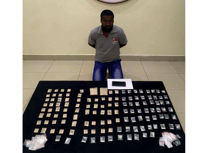 المتهم وأمامه المضبوطات