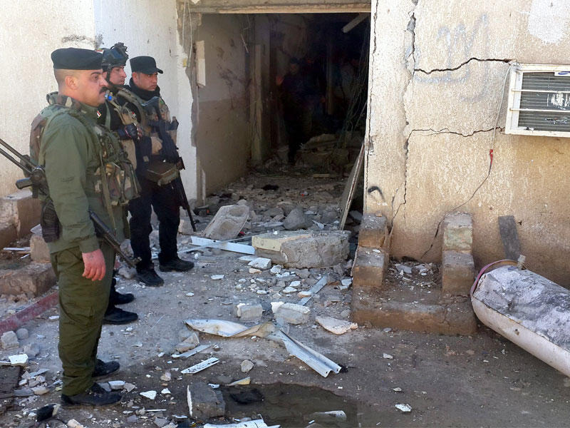 جنود عراقيون يتفقدون أمس الأضرار في مركز شرطة المتوكل الذي تعرض لهجوم من 4 انتحاريين مساء أمس الأول (إي بي أيه)