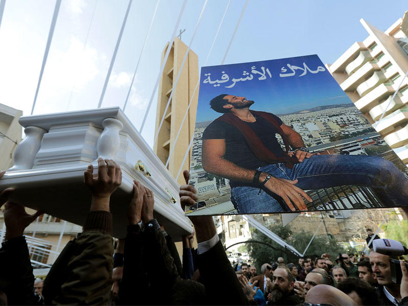 نعش إلياس ورديني الذي قتل في هجوم إسطنبول يمر أمام صورة نصبت له في حي الأشرفية ببيروت أمس (أ ف ب)