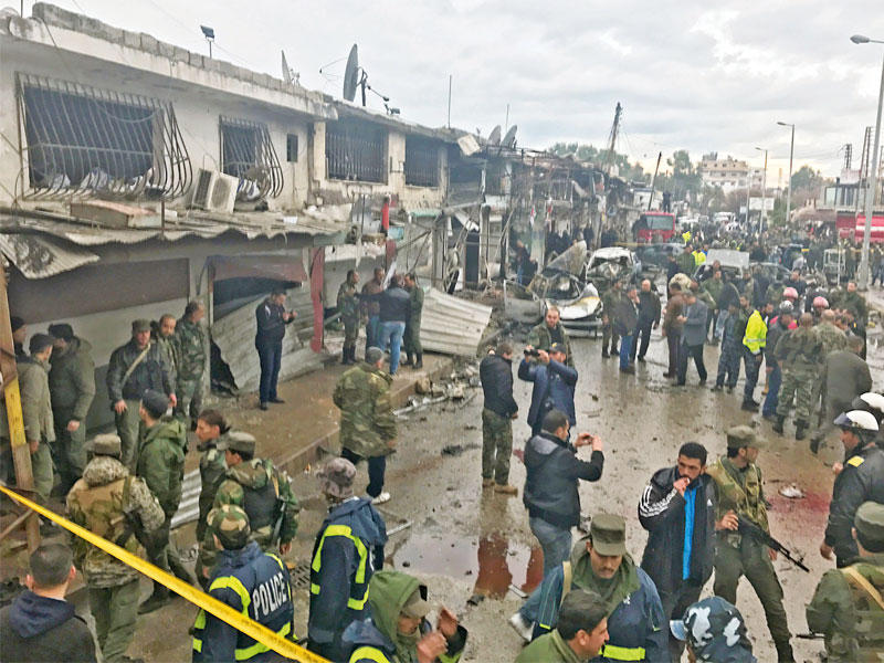 سوريون في موقع تفجير جبلة أمس (أ ف ب)