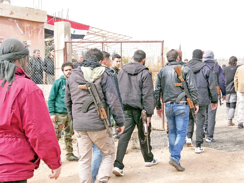 صورة نشرتها وكالة «سانا» الرسمية أمس الأول لمسلحين معارضين لدى وصولهم لتعديل أوضاعهم في ريف دمشق الجنوبي الغربي 