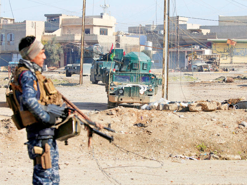 جندي عراقي يؤمن رتلاً يستعد للانتشار في حي الوحدة شرق الموصل أمس  (رويترز)n